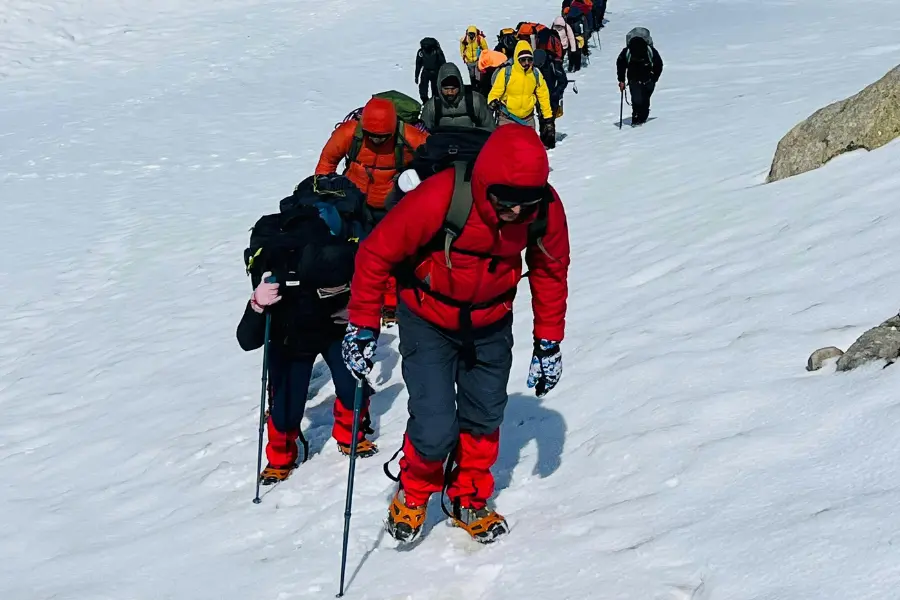 people hiking with full gear on a snow covered terrain.
