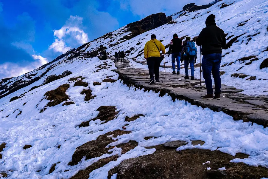 people trekking on a snow covered trail.