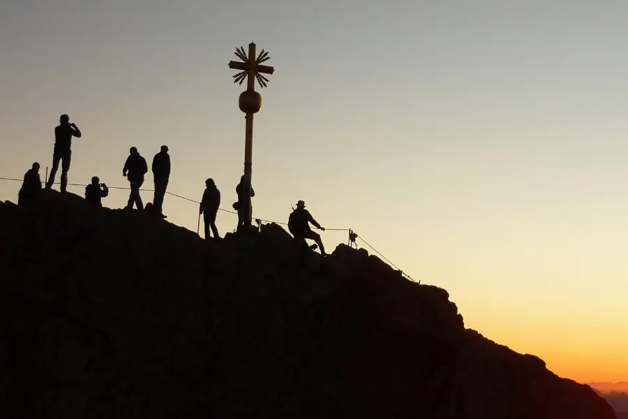 view of people climbing himalayan mountain peak during sunrise