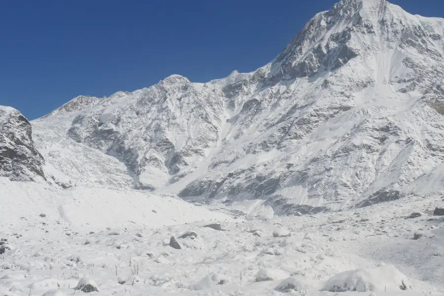 Snow-covered Himalayan mountain landscape under clear blue sky